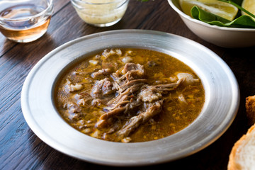 Turkish Soup Beyran with Lamb Meat, Rice, Chopped Garlic and Vinegar Sauce Served with Salad.