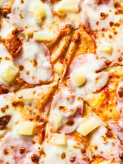 surface of pizza with ham and pineapple