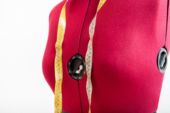 red dress form with measuring tape close up
