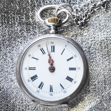 antique pocket watch on silver cloth close up