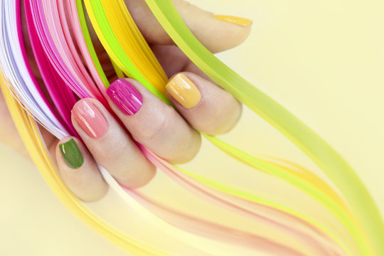 Colorful Multi-colored Manicure On Short Nails On Yellow Background.Nail Art.Pink, Green ,yellow, Peach Nail Polish.