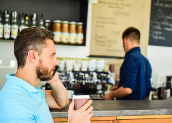 Guy busy speak phone while relax coffee break. Ready to hear you. Man holds cup of drink while have...