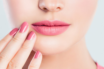 Perfect female lips closeup. Pink lips makeup and manicured nails with pink nail polish