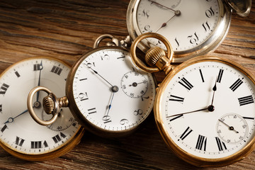 vintage pocket watches on aged wood