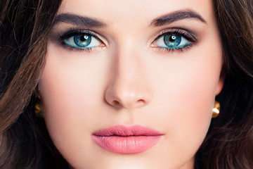 Woman face closeup. Beautiful female model with makeup. Blue eye shadow, pink lipstick