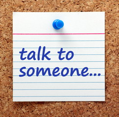 Advice to Talk To Someone written on a card pinned to a cork notice board as a reminder to share your problems