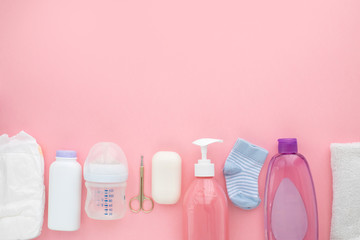 Set for a newborn nipple bottle diaper socks baby body slip pink background top view Children's...