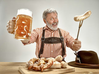 Germany, Bavaria, Upper Bavaria. The senior happy smiling man with beer dressed in traditional...