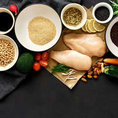 Healthy food clean eating Сhicken breast vegetables nuts chickpeas quinoa seeds dark stone background copy space top view
