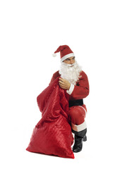 santa claus searching for presentsinside the bag isolated on white