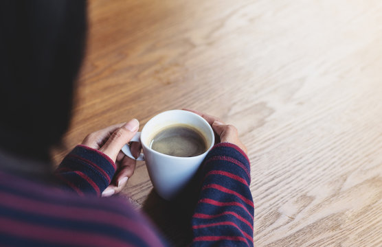 Woman holding a cup of hot coffee, winter seson