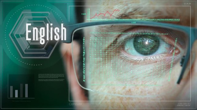 A close up of a businessman eye controlling a futuristic computer system with an English concept.