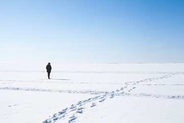 Footsteps of lonely girl walking on frozen sea