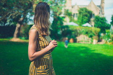 Woman standing on lawn in lush garden
