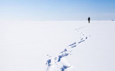 Footsteps of lonely person walking on snow