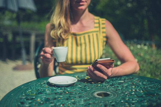 Woman drinking coffee in garden of cafe