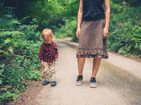 Mother and toddler walking in forest