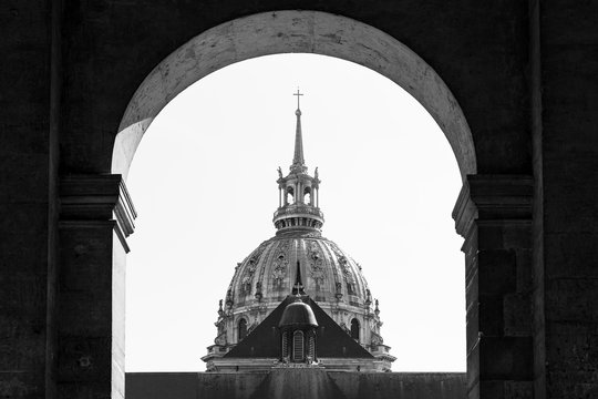 Fototapeta The golden dome of Les Invalides seen through the gate in Paris, France, in black and white  
