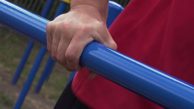 Slow Motion - Close-up - Male Athletic Man Exercising on Parallel Bars. Street Workout and Outdoors Training.