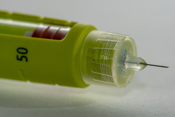 Extreme close up of a yellow disposable insulin injector