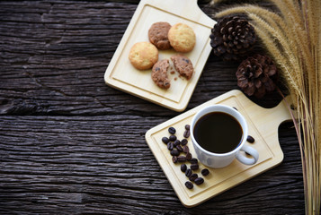 black coffee and cookie on wooden table