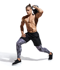 Sportive man workout with kettlebell doing lunges. Photo of handsome man with good physique isolated on white background. Strength and motivation