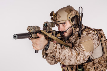 Special forces United States soldier or private military contractor holding rifle. Image on a white...