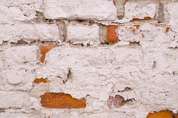old vintage brick wall with shabby white paint background. architecture, texture.