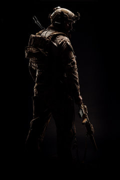 Special forces United States soldier or private military contractor holding rifle. Image on a black background.