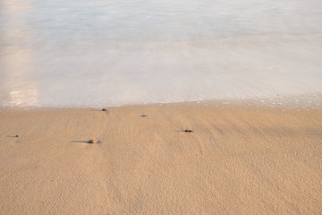 Low tide waves wash up on the fine grain sands of Old Orchard Beach Maine