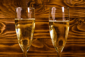 Two wineglasses with champagne on wooden table