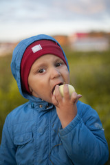 boy eating an Apple in the garden