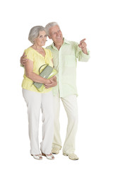 portrait of senior couple pointing something on white background