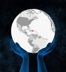 Dominican Republic on white globe in hands