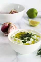 Freshly prepared tzatziki sauce, on white marble