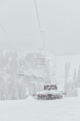 Snowcat preparing a slope in high mountains at skiing resort