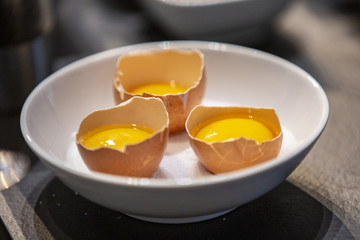 Open chicken eggs inside a boll ready to cook.