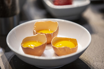 Open chicken eggs inside a boll ready to cook.