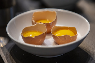 Open chicken eggs inside a boll ready to cook.
