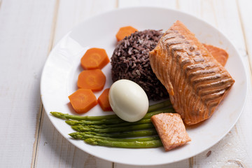 Health food concept, salmon with rice and vegetable on wood background