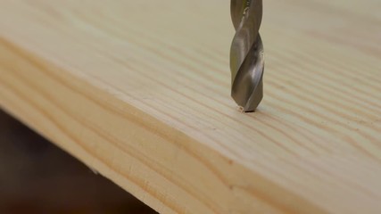 Macro of a drill bit drilling wooden plank. Outdoors. Copy space.