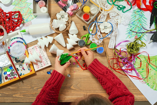 Childrens making decorations for new year holiday. Painting watercolors. Top view. Artwork workplace with creative accessories.