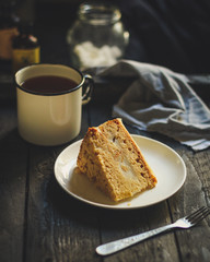 cake a piece, with cream on a white plate. Top view rosemary. food background