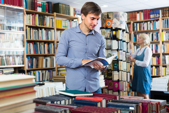 man looking at open book