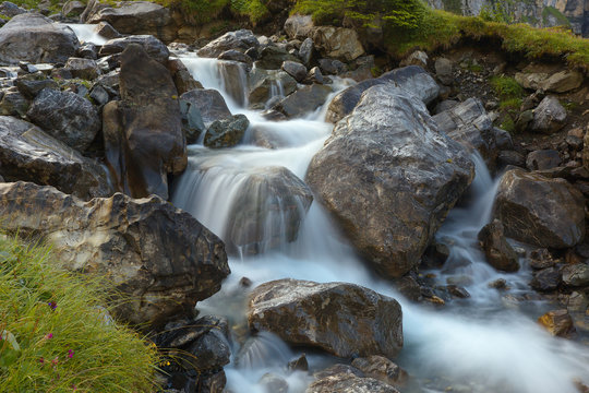 Mountain brook with flowing water on the stones, long exposition