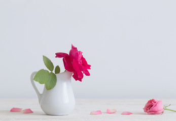 beautiful roses in jug on wooden table