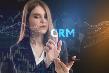 The concept of business, technology, the Internet and the network. A young entrepreneur working on a virtual screen of the future and sees the inscription: CRM