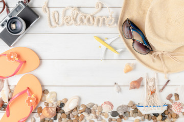 welcome text with summer accessories, sandals and shell