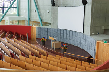 A large lecture hall at the university or at school. Tribune, screen for presentations and a...
