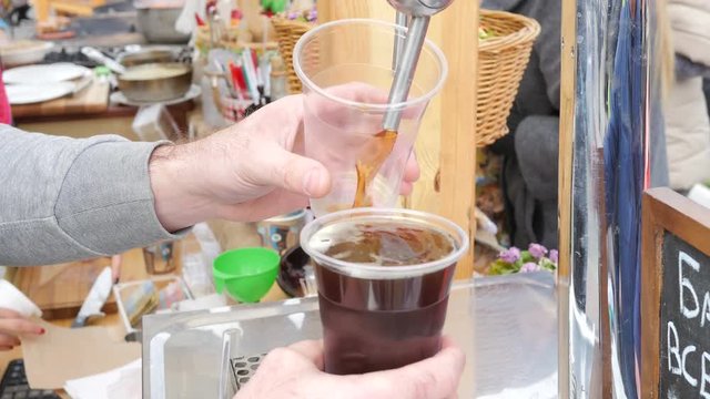 Barman pouring a beer in a cup in a street food market fair